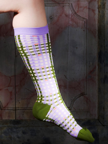 Someone wearing the knee-length socks with lavender and green checkered pattern from Henrik Vibskov.