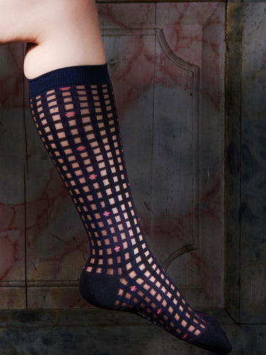 Someone wearing the knee-length socks with a navy checkered pattern from Henrik Vibskov.