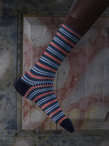 Close-up of a leg wearing the Safety Socks Homme in Navy Safety from Henrik Vibskov Spring/Summer 2026 Studio Collection, highlighting the navy colour and striped knit pattern.