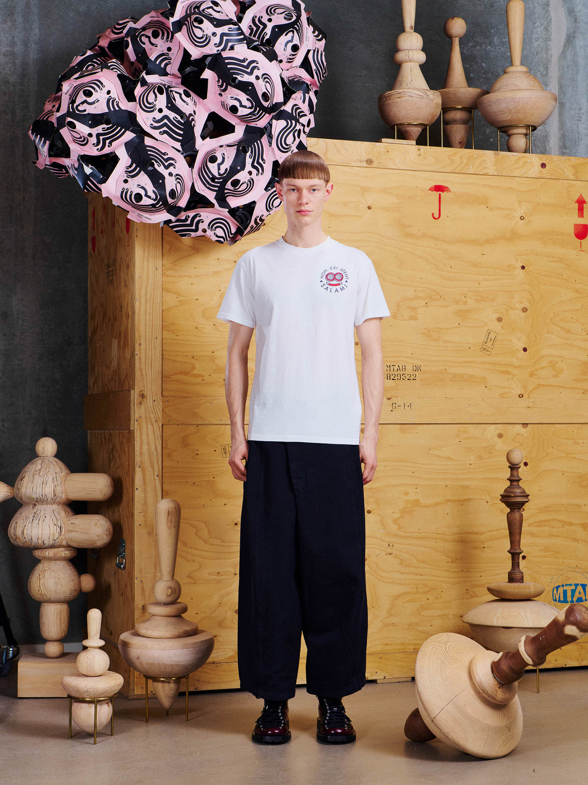 Henrik Vibskov Salami Tee in Cloud worn by male model with black wide-leg trousers
