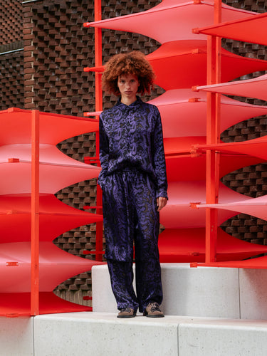 Model wearing Henrik Vibskov Shants Pants in Victorian Burnout, shown from the front with relaxed fit and layered straight legs.