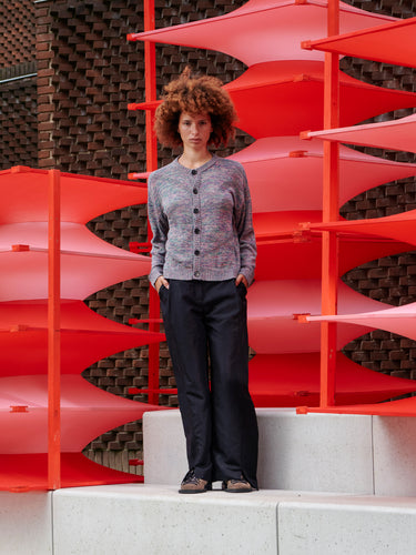 Front view of a model wearing the cardigan, showing the loose fit, round neckline, and button closure.