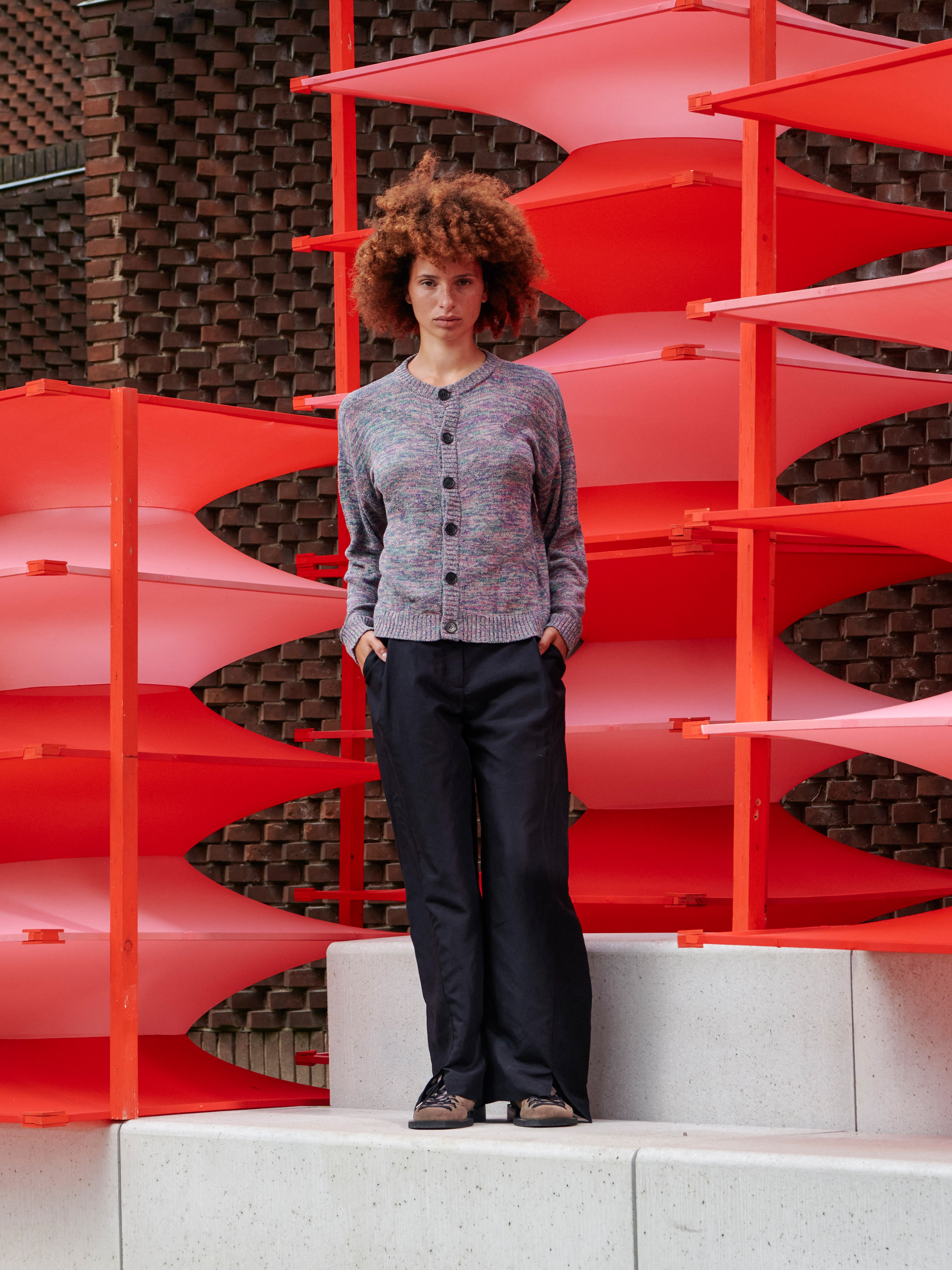 Front view of a model wearing the cardigan, showing the loose fit, round neckline, and button closure.