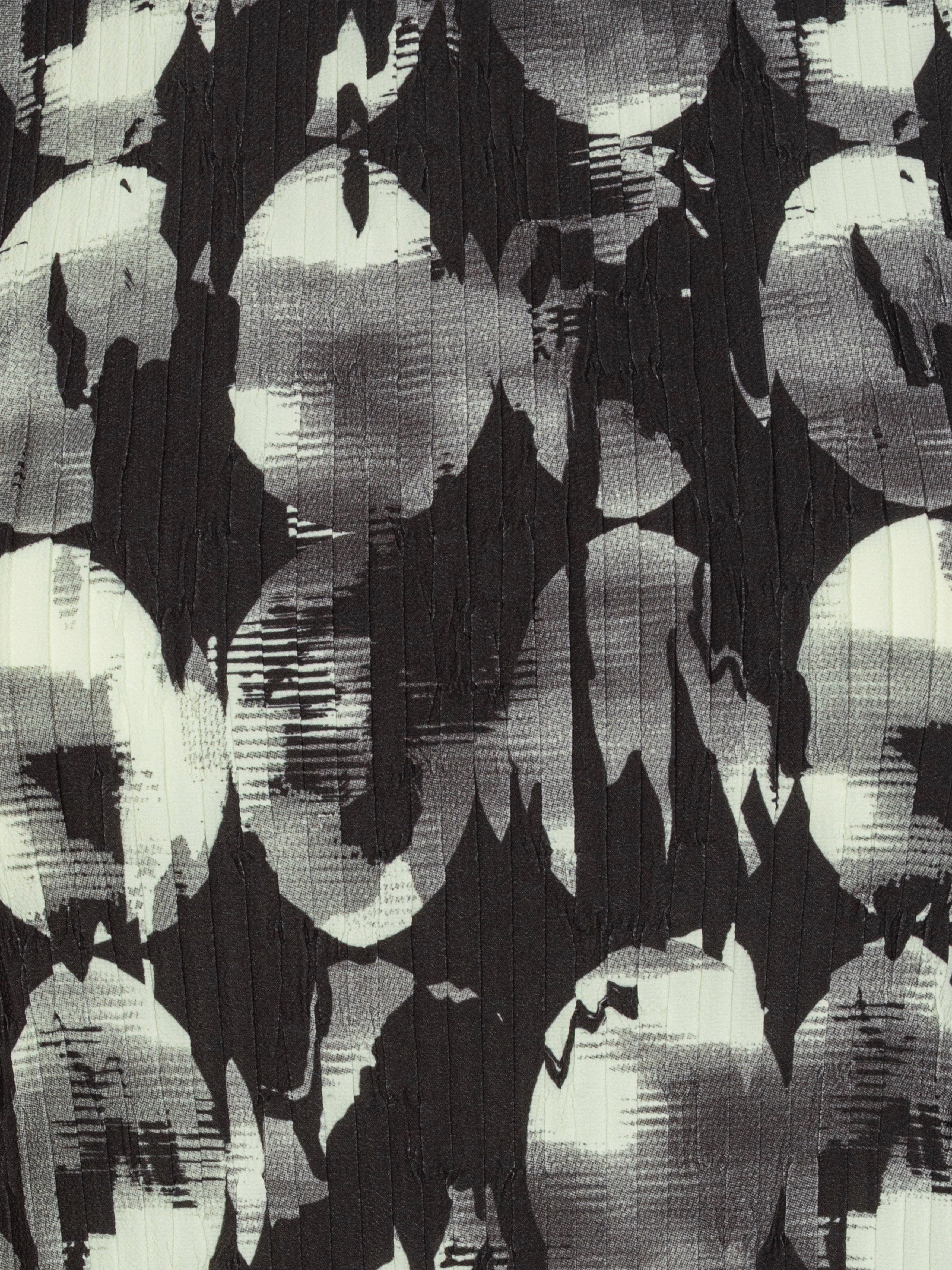 Close-up of the black and white abstract pattern top with plissé material