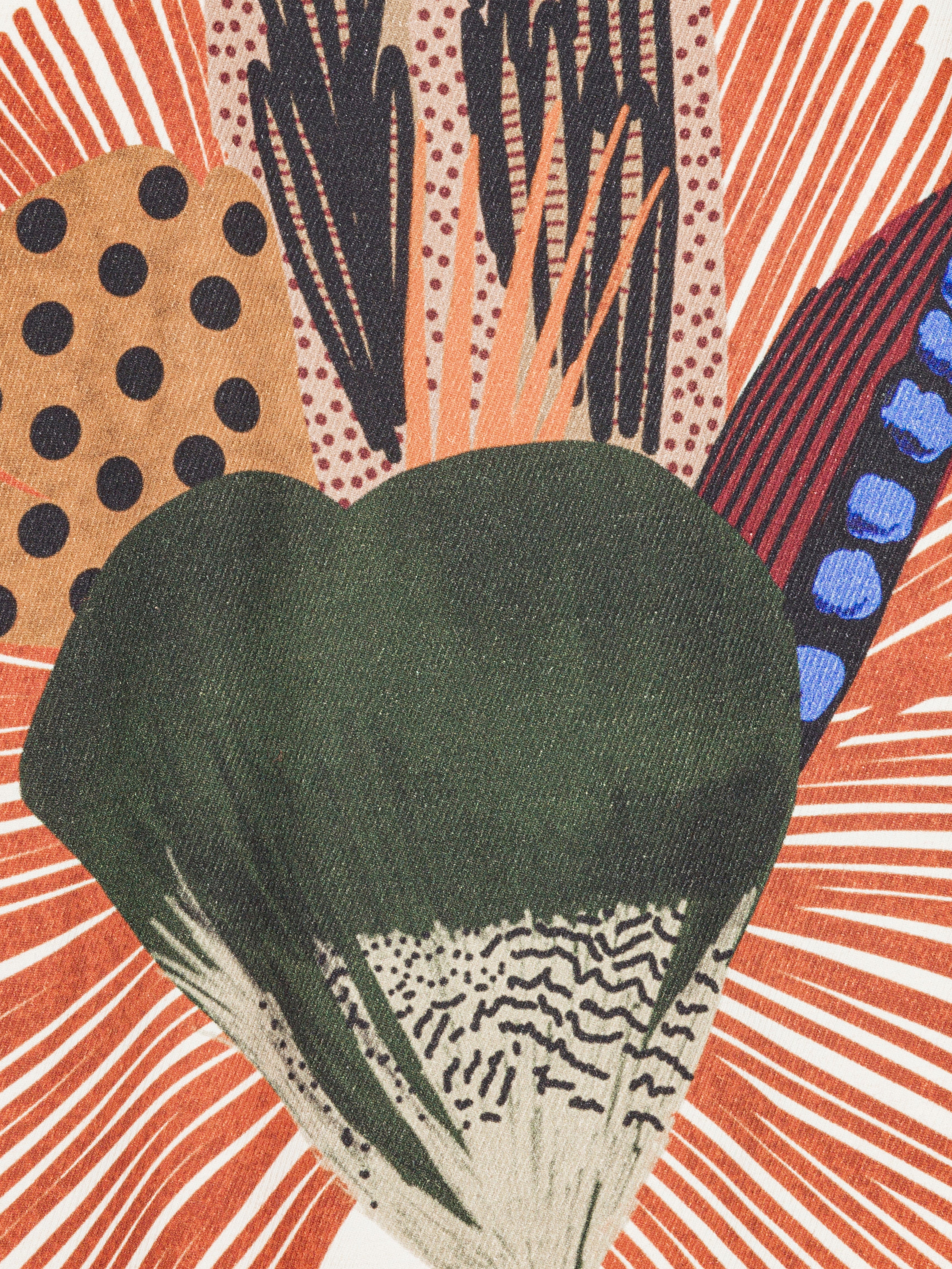 Close-up of a colorful abstract pattern with a green leaf-like shape in the center on a shirt