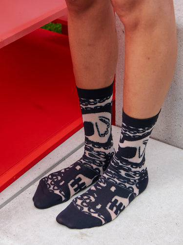 Model wearing Victorian Socks Femme in Black Victorian, highlighting the black semi-transparent fabric with abstract Victorian illustration.