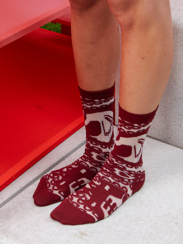 Model wearing Victorian Socks Femme in Lilac Victorian, featuring purple-red semi-transparent fabric with abstract Victorian illustration.