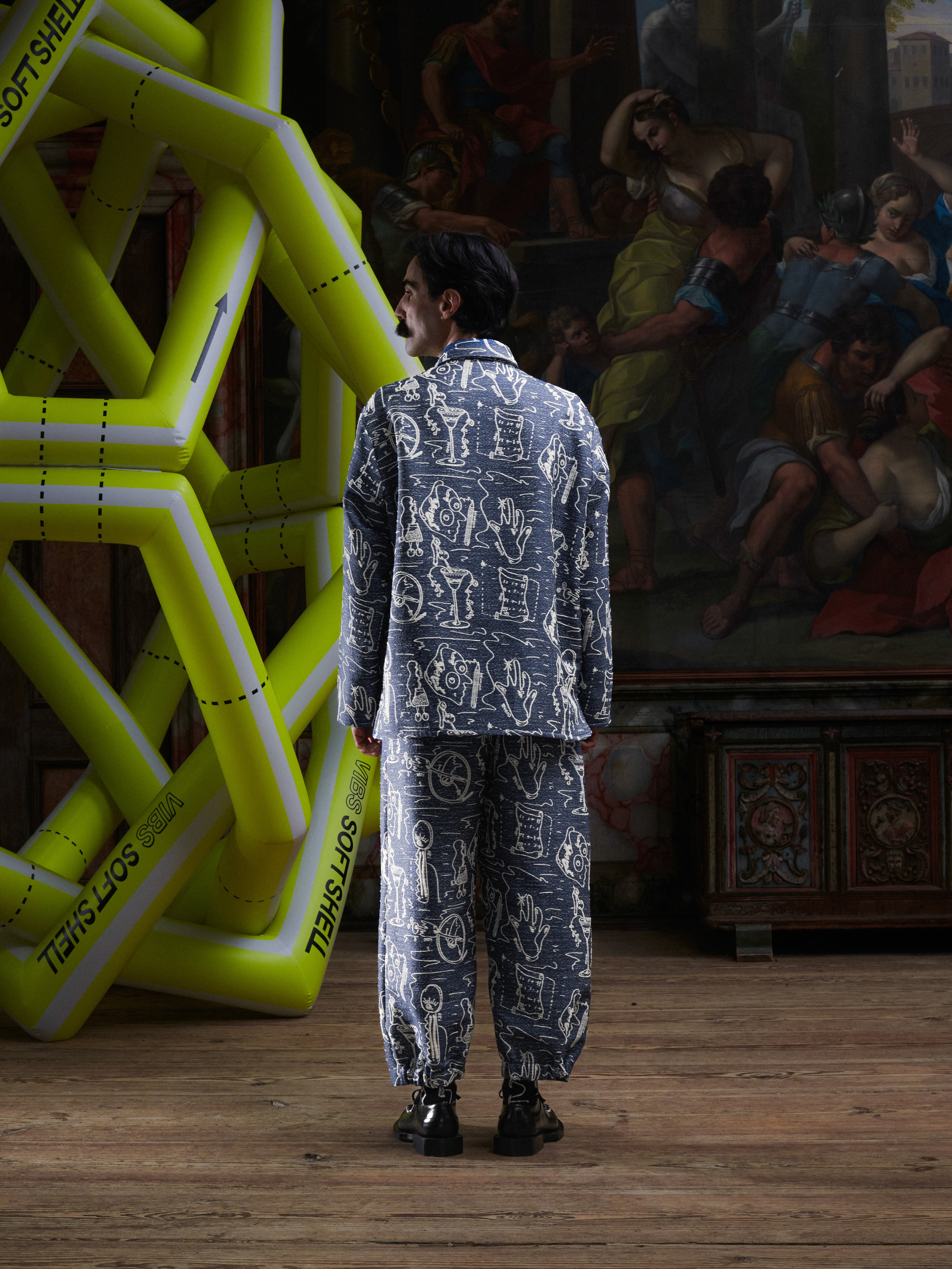 Back view of model wearing the Wheel jacket in a doodle print by Henrik Vibskov