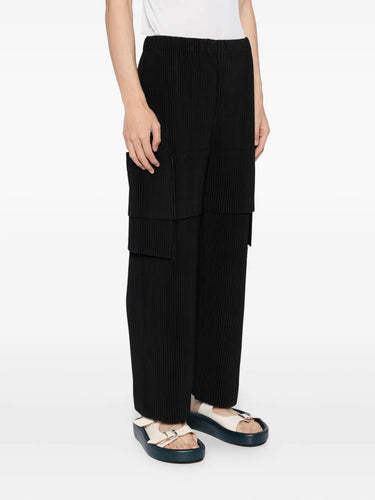 Person wearing black cargo pants on a white background