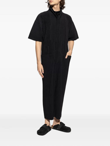 Person wearing a black jumpsuit with a white background