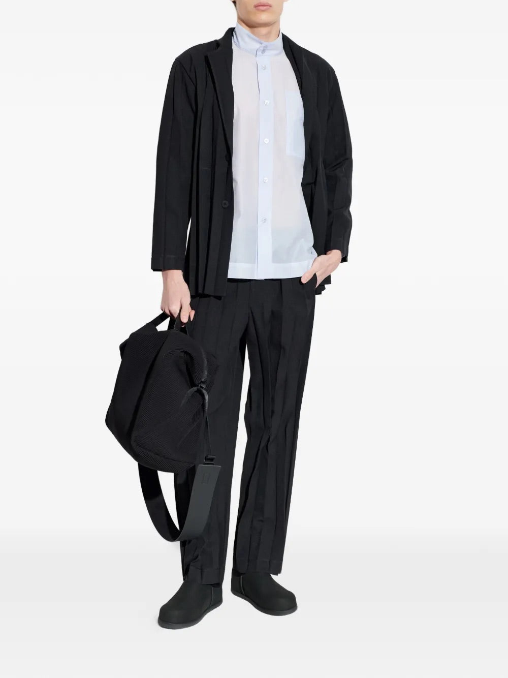Model wearing Edge Ensemble Jacket in Black by Homme Plissé Issey Miyake, full-length front view of black large plissé blazer with notched collar and two-button closure