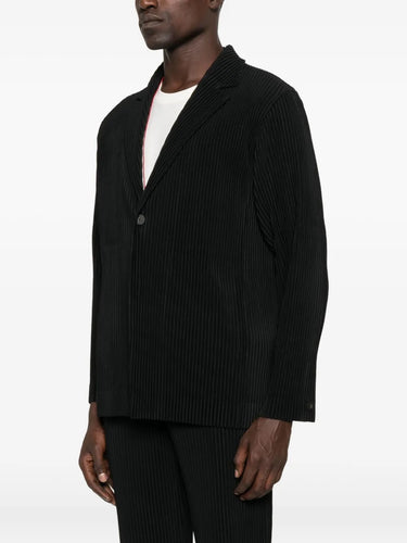 Man wearing a black plissé suit on a white background