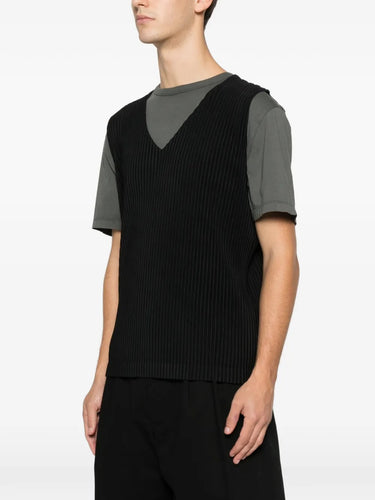 Side profile of the black plissé vest from Homme Plissé Issey Miyake on a white background.