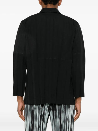 Back view of the black blazer with large plissé from Homme Plissé Issey Miyake on a white background.