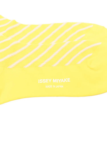 Closeup of the foot section of Issey Miyake December AW25 Generic Stripes Socks in yellow, showing crew-length fit and bold striped design.