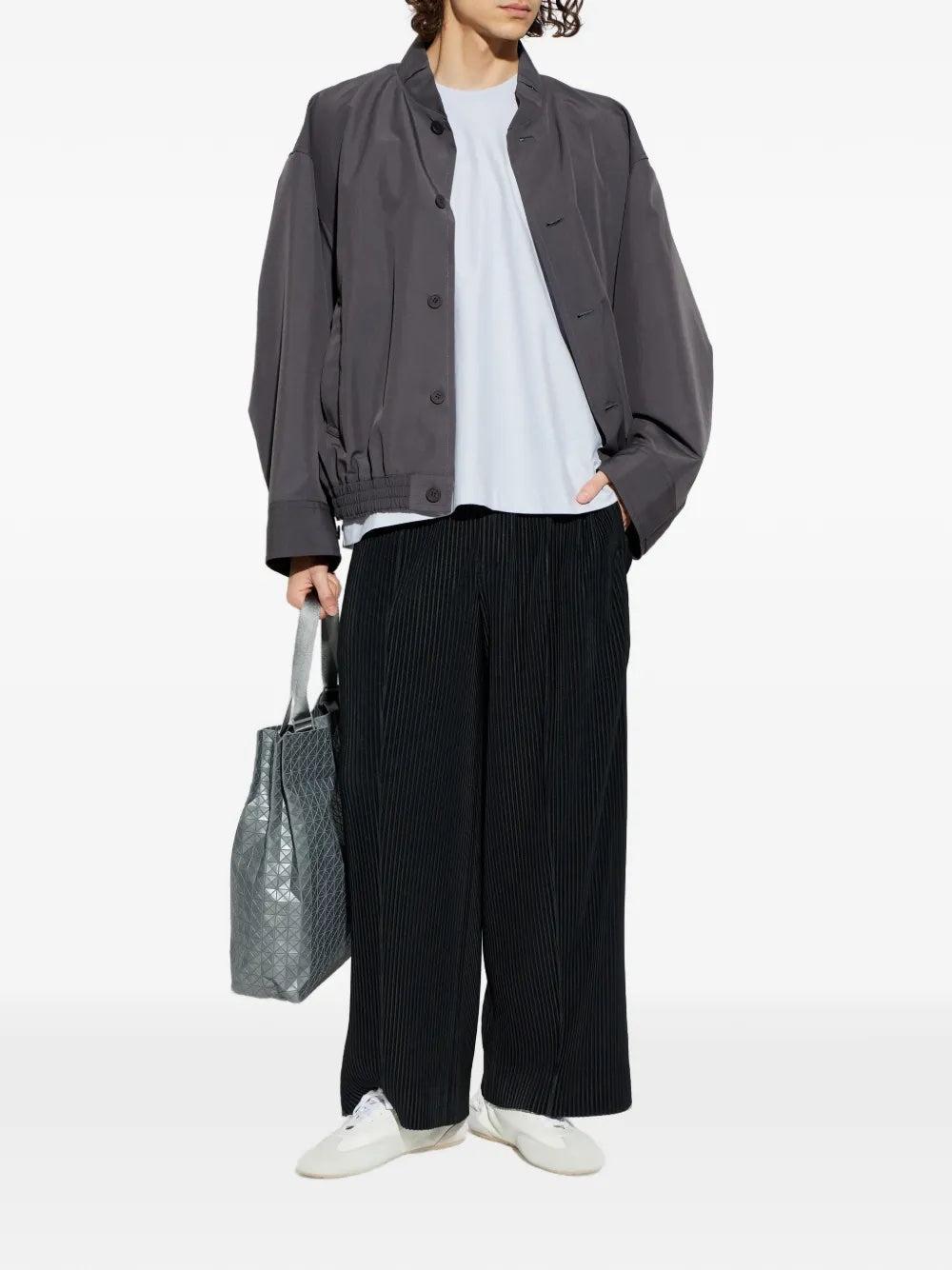 Male model wearing the charcoal January Carrier Carried Blouson from the front, showing the structured high neck, buttoned front, and relaxed silhouette.
