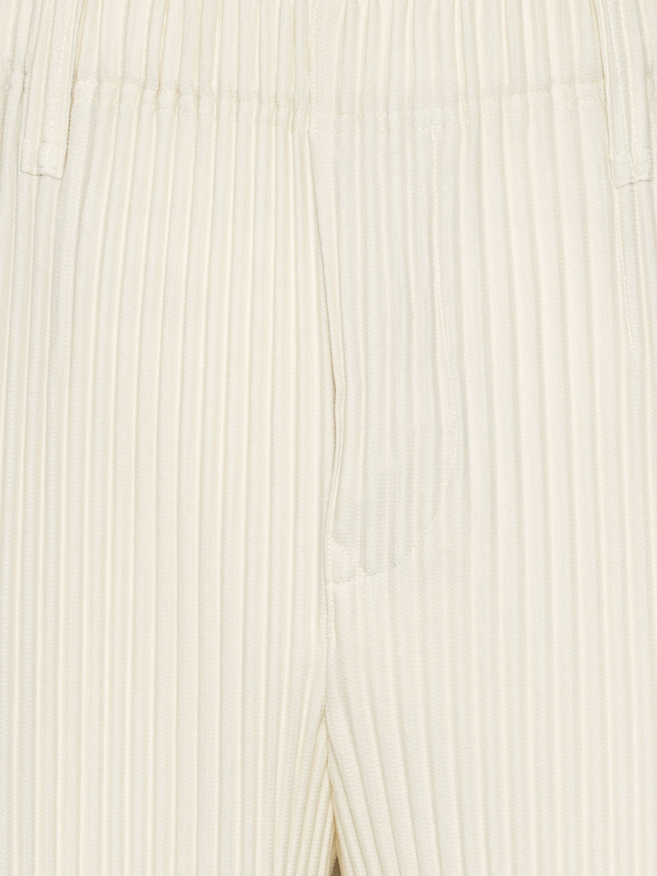 Close-up of off-white plissé pants with straight legs from Homme Plissé Issey Miyake