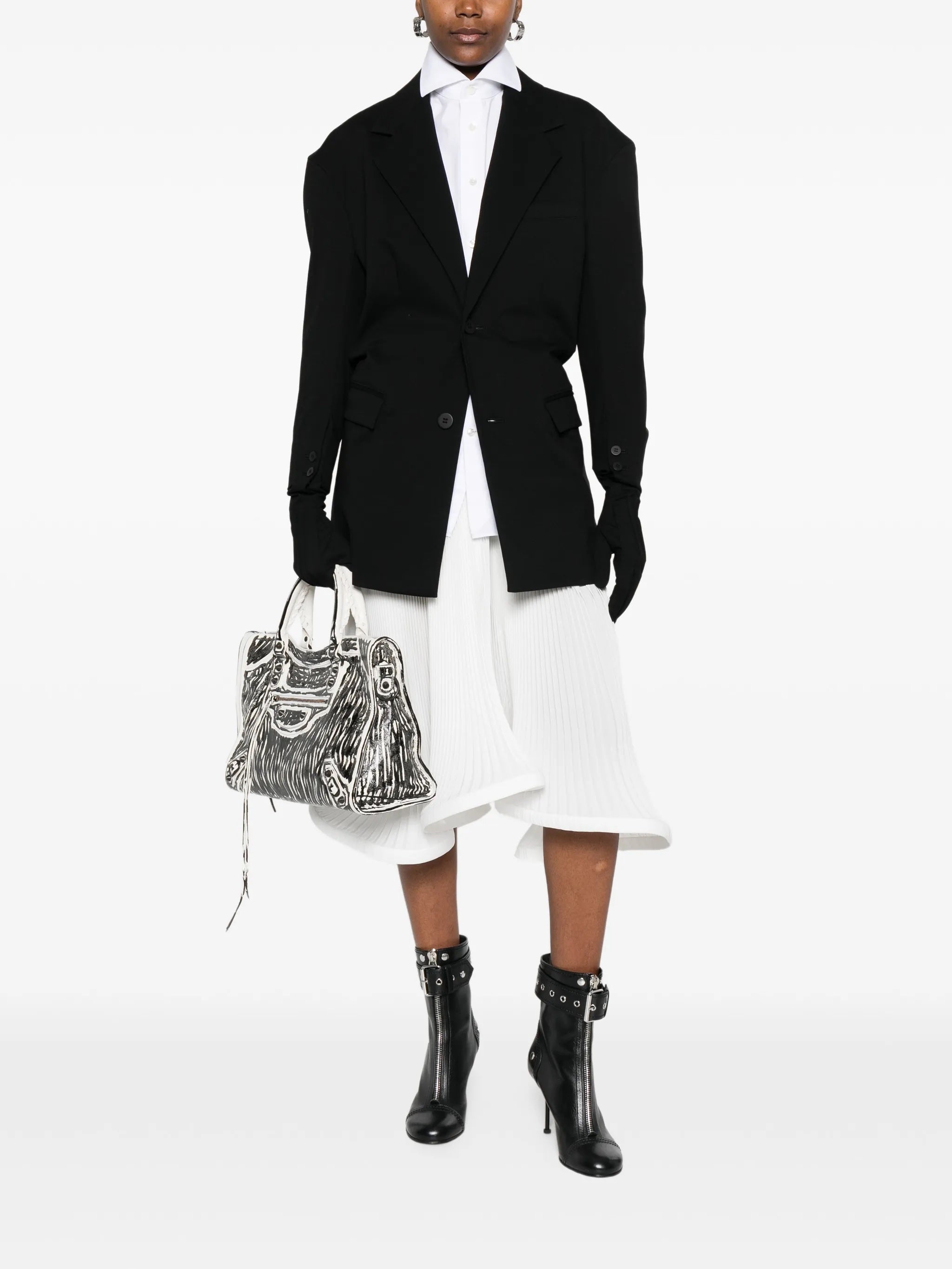 Front view of model wearing the black blazer with gloves attached to sleeves from Issey Miyake on a white background