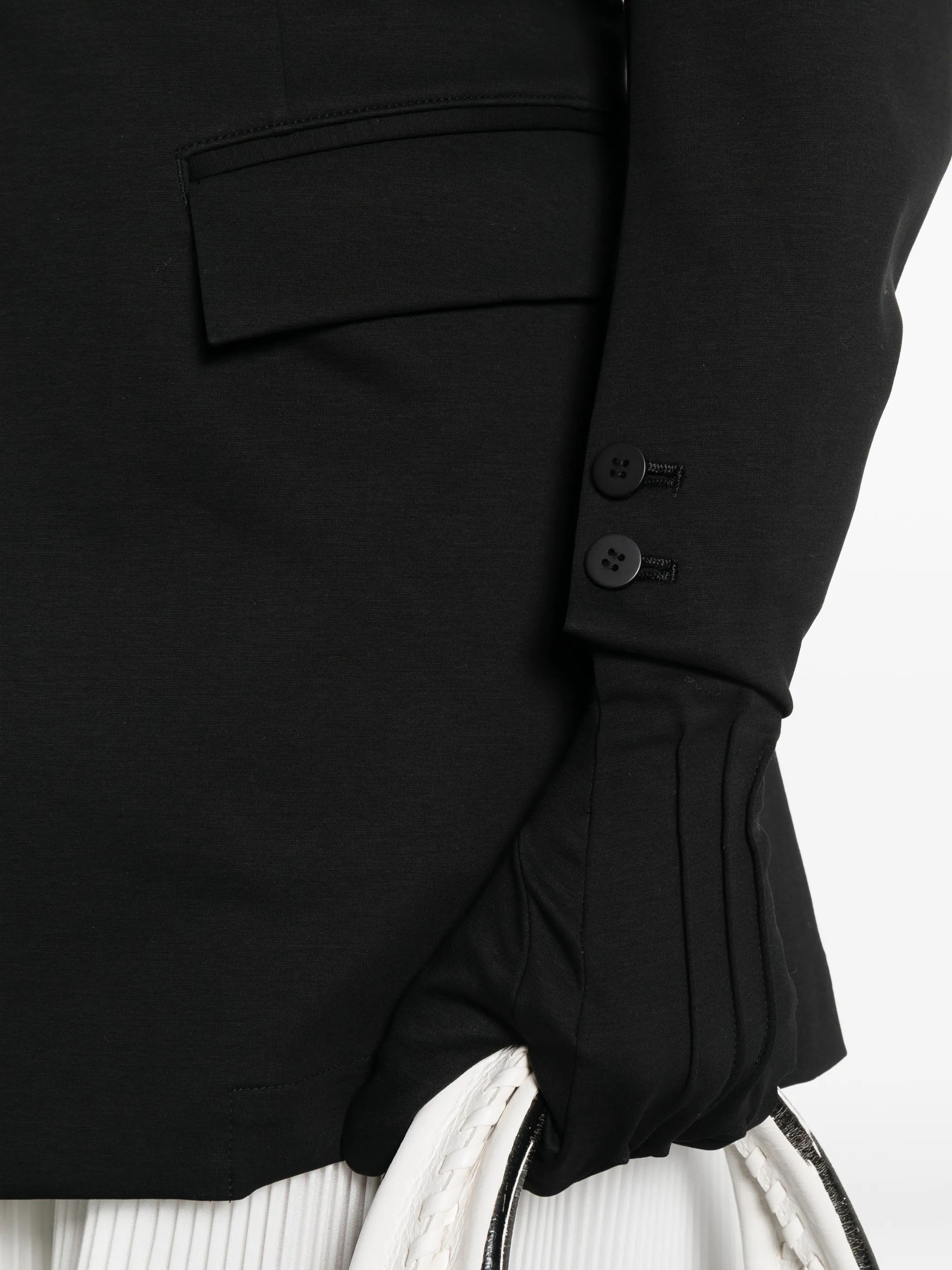 Close-up of the gloves attached to the blazer sleeves from Issey Miyake