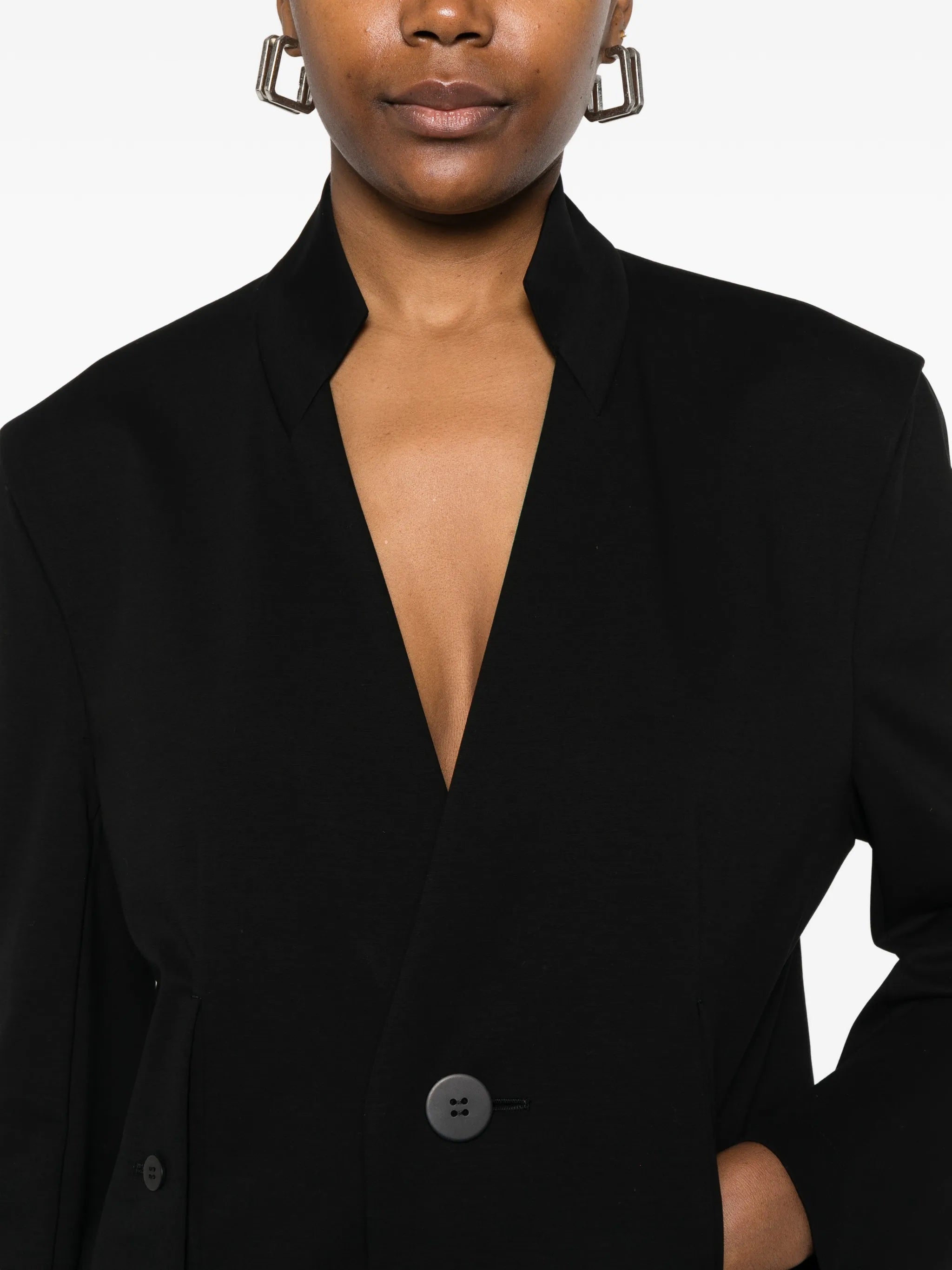 Close-up detail of the front of the black, single-breasted blazer from Issey Miyake on a white background
