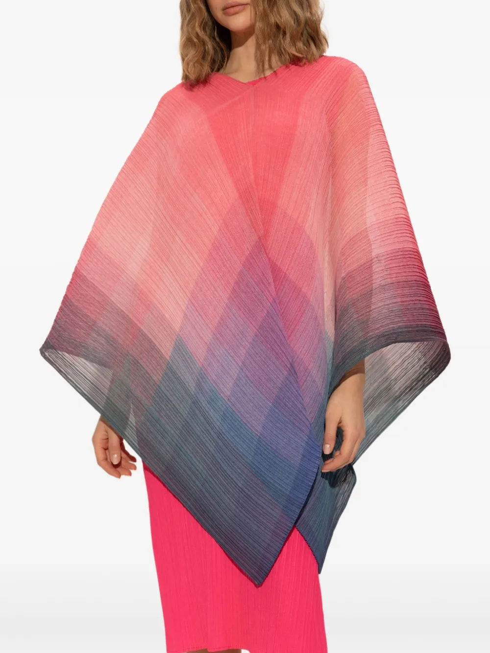 Woman wearing a colorful gradient pleated poncho on a white background