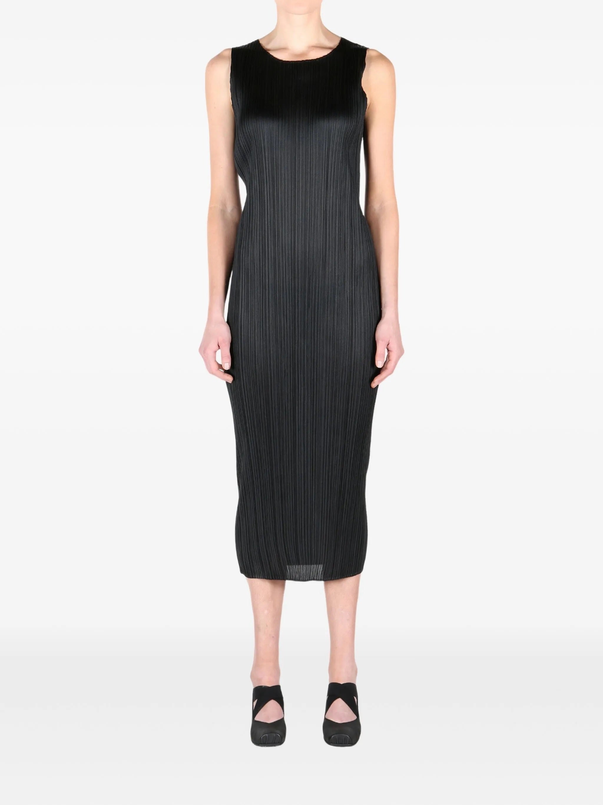 Black sleeveless pleated dress worn by a person on a white background