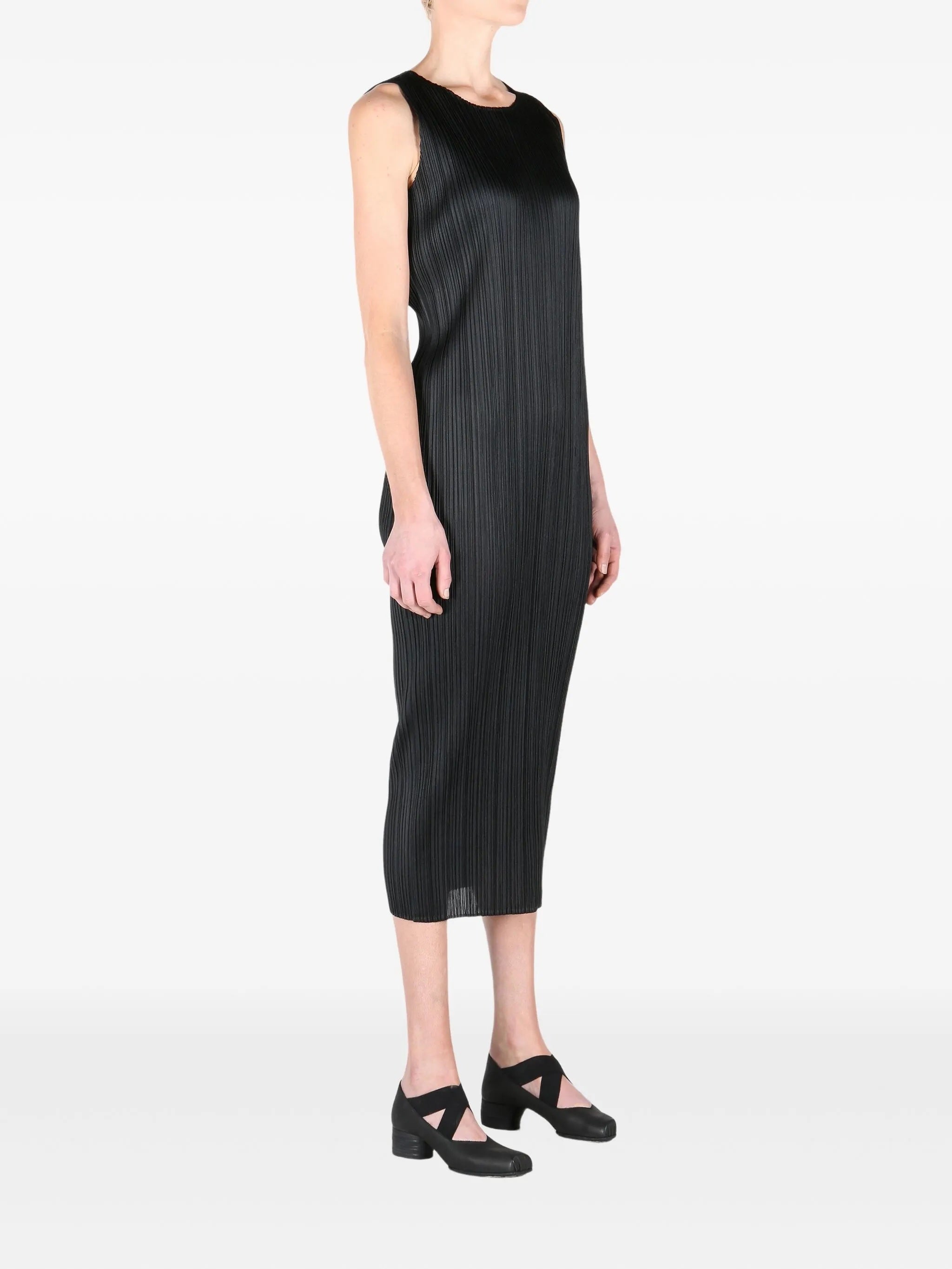 Black sleeveless pleated dress worn by a model on a white background