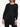 Woman wearing a black pleated outfit from Pleats Please Issey Miyake on a white background