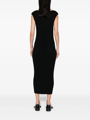 Person wearing a black ribbed dress on a white background
