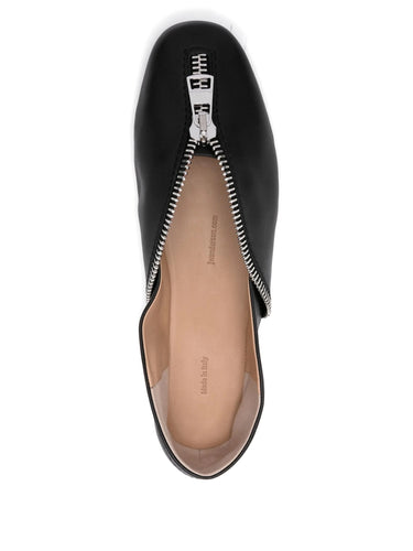 Black flat shoe with a zipper detail on a white background