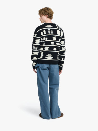 Person wearing a black sweater with white patterns on a white background
