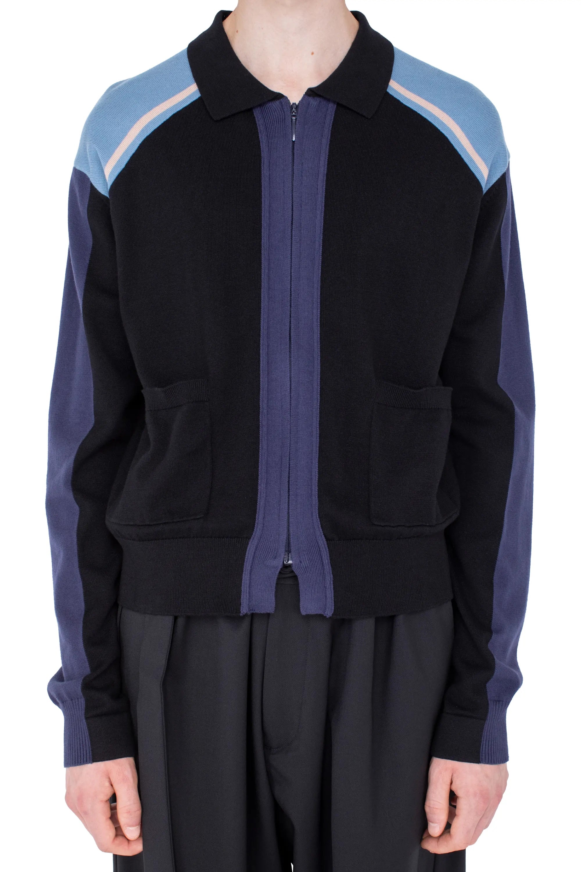 Model wearing Kiko Kostadinov Munno Knit Cardigan in Phantom Black showing zip front, polo collar, colour-block shoulders and patch pockets