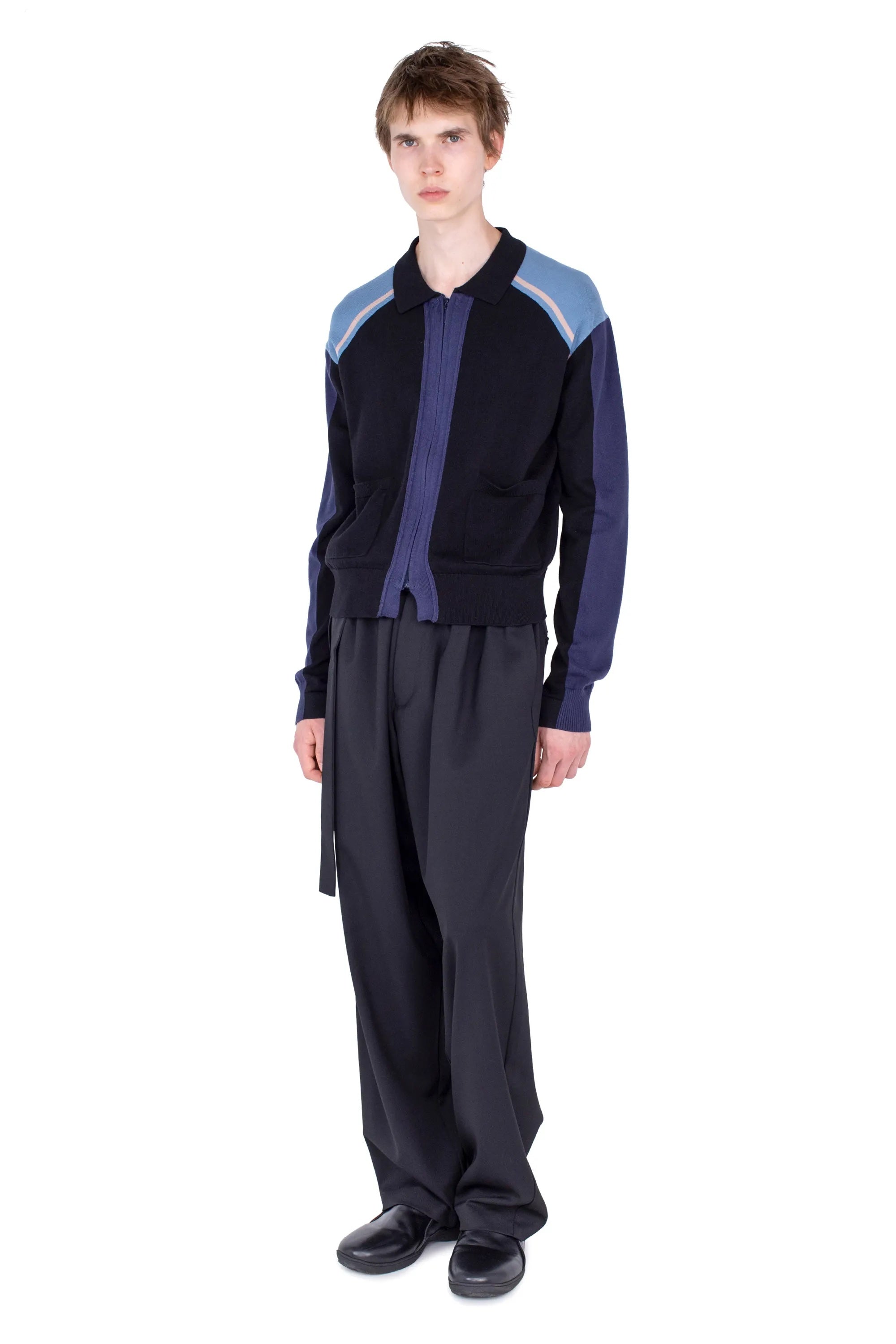 Angled view of Kiko Kostadinov Munno Knit Cardigan in Phantom Black with blue sleeve panels, light blue shoulders and ribbed trims
