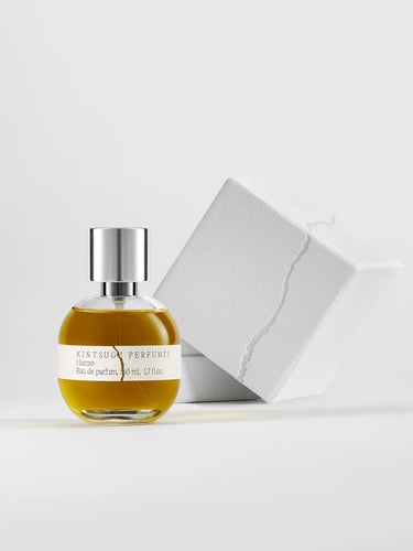 Perfume bottle with its white box packaging on a light background