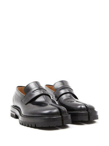 Pair of black leather shoes with chunky soles on a white background