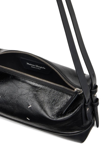 Maison Margiela Baguette Small Bag in Black/Black, diagonal closeup showing the smooth calf leather and metallic hardware details.