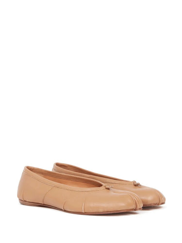 Pair of beige ballet flats on a white background