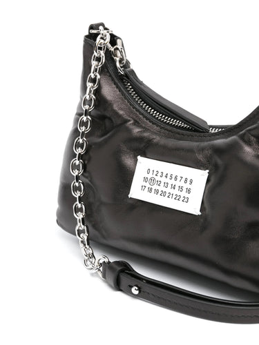 Close-up of Glam Slam Hobo Micro in Black by Maison Margiela highlighting the padded texture and signature number logo plaque.