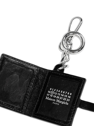 Close-up of the interior of the Maison Margiela ID Photo Holder, revealing the black leather lining, press-stud fastening, and brand number logo.