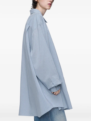 Close-up, side view of model wearing the long-sleeved shirt in light blue and grey from Maison Margiela