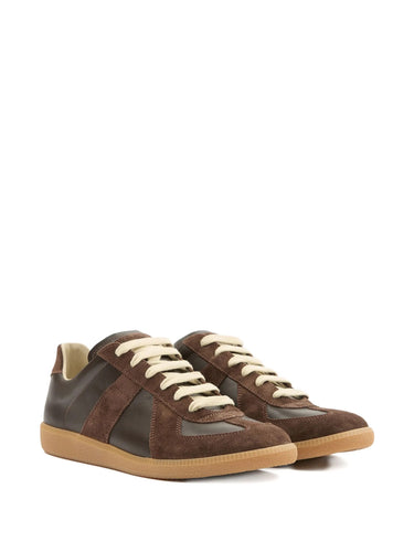 Pair of brown sneakers with white laces on a white background