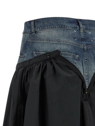Close-up of a black skirt and blue jeans on a white background