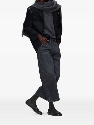 Model wearing the black washed denim jeans from Maison Margiela