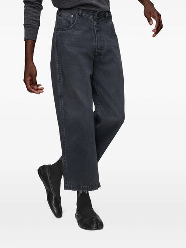Front view of model wearing the black washed denim jeans from Maison Margiela