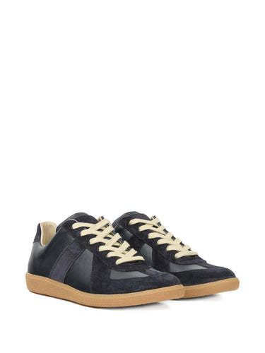 Pair of dark navy blue leather sneakers with panel design and rubber soles on a white background