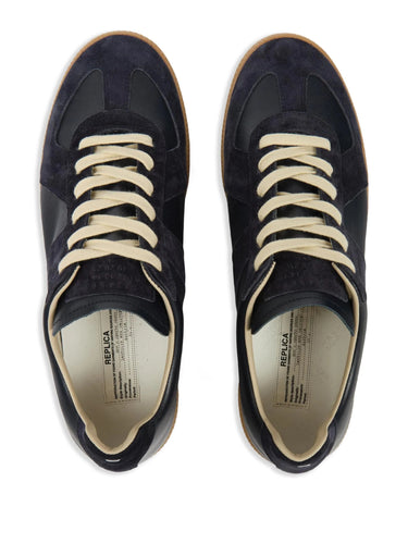 Top view of dark navy blue leather sneakers with panel design and insole logo on a white background