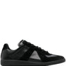 All black leather sneakers with panel design from Maison Margiela on a white background