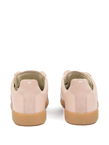 Back view of soft pink leather sneakers with white detail stitch from Maison Margiela on a white background