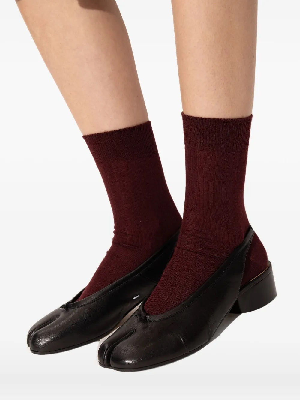 Person wearing the black Tabi New Ballerina Slingback 30mm shoes, showing the split-toe front, slingback fit, and low heel in a styled on-body look.