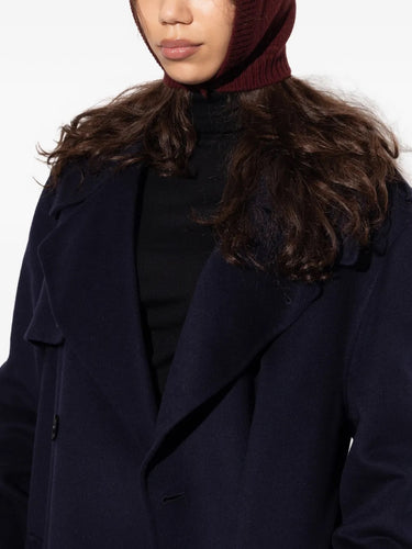 Detail shot of a female model wearing the Maison Margiela Beanie in Burgundy, showcasing the ribbed knit texture, buttoned balaclava style, and signature Four Stitch motif in a styled look.